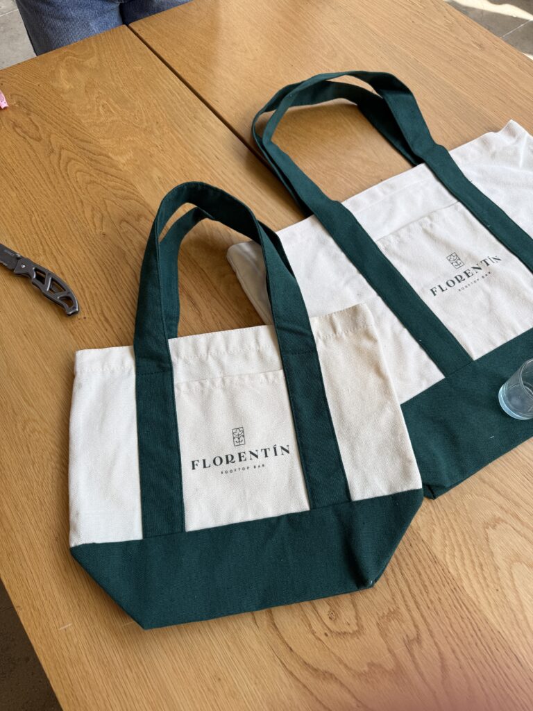 Two Florentín canvas totes on a wooden table